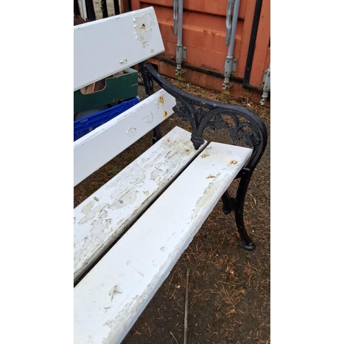 66 - outdoor bench with cast iron floral-patterned sides and white-painted wooden slats.