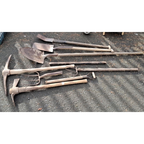 68 - Mixed lot of garden tools comprising shovels, pickaxes, and pitchforks.