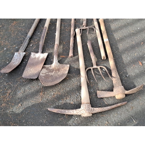 68 - Mixed lot of garden tools comprising shovels, pickaxes, and pitchforks.