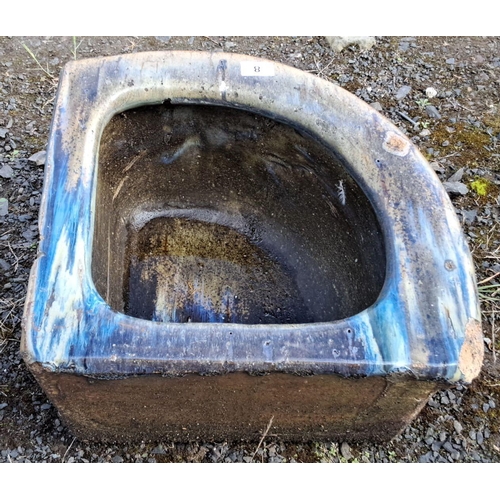 8 - Rustic stone corner trough with weathered patina, rounded edges, and faint blue accents.