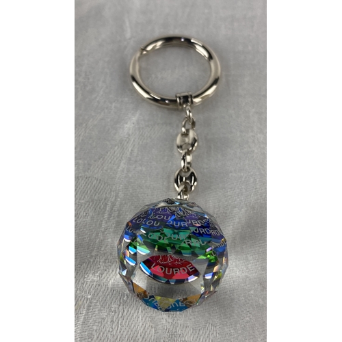 101 - Clear crystal keychain with faceted charm, featuring coloured engravings of 