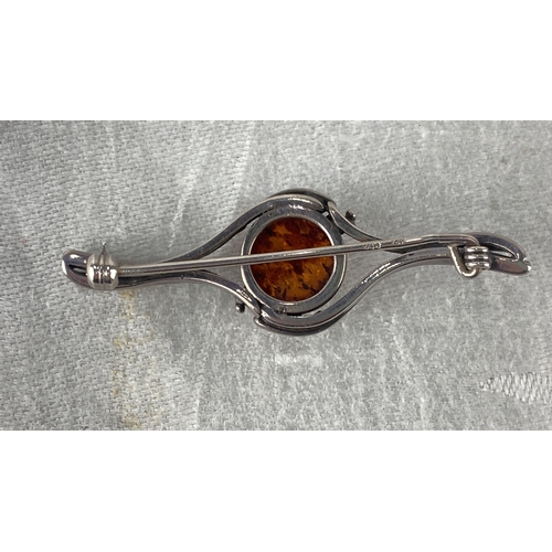 97 - Sterling Silver brooch with an amber gemstone features a swirling design. It is marked 925.