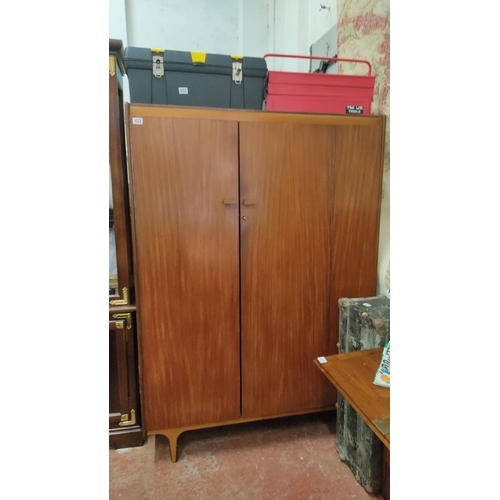 433 - Mid-Century Modern wardrobe features mahogany veneer, dual doors, and interior shelving with hanging... 