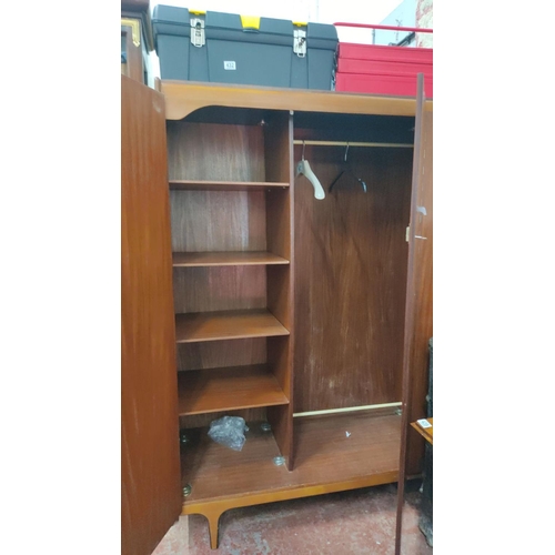 433 - Mid-Century Modern wardrobe features mahogany veneer, dual doors, and interior shelving with hanging... 