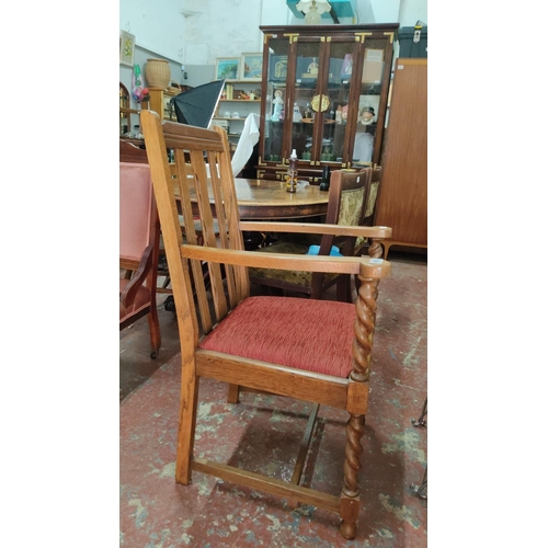 456 - Edwardian oak armchair features barley twist legs and arm supports, a slatted backrest, and a red up... 