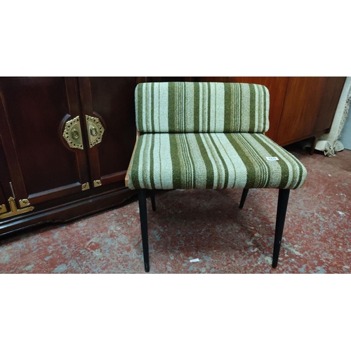 460 - Mid-Century Modern chair with green-striped upholstery and wooden frame, featuring black tapered leg... 