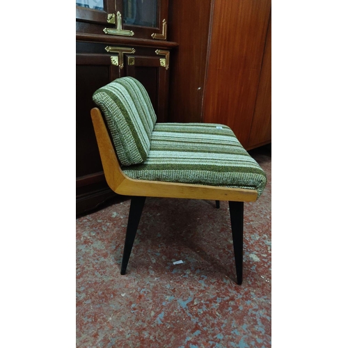 460 - Mid-Century Modern chair with green-striped upholstery and wooden frame, featuring black tapered leg... 