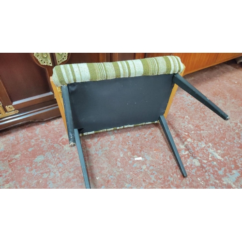 460 - Mid-Century Modern chair with green-striped upholstery and wooden frame, featuring black tapered leg... 