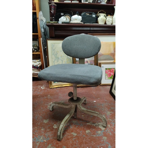 464 - Vintage industrial-style office chair with grey upholstered seat and backrest on a metal base.