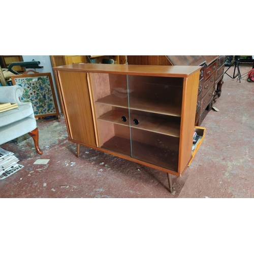 471 - Mid-Century Modern teak sideboard with sliding glass doors, storage compartments, and tapered legs, ... 