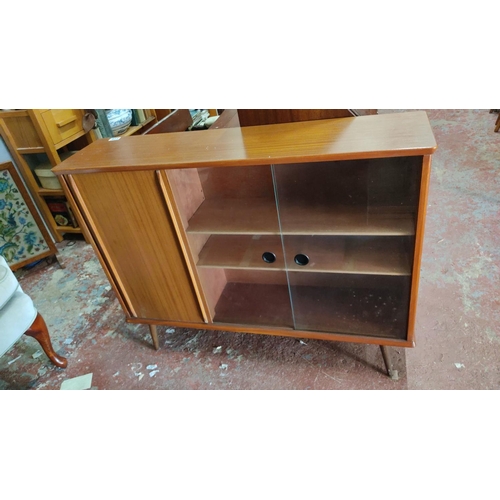 471 - Mid-Century Modern teak sideboard with sliding glass doors, storage compartments, and tapered legs, ... 