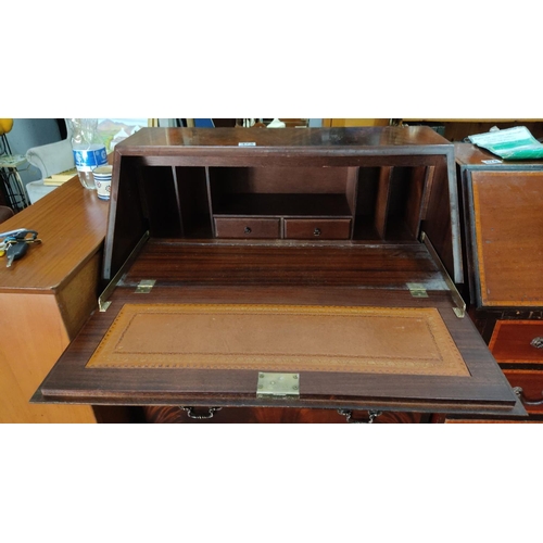 473 - Mahogany writing bureau with three drawers and a drop-down front revealing interior compartments and... 