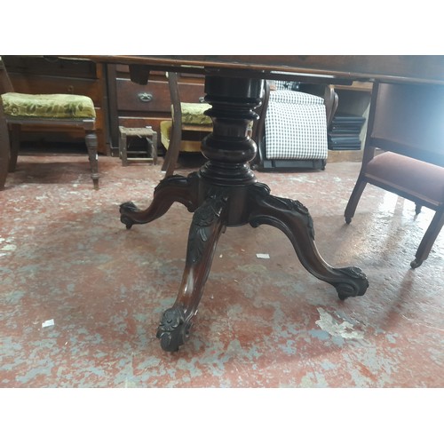 462 - Victorian-era oval tilt-top dining table in rich mahogany with intricately carved pedestal base., me... 