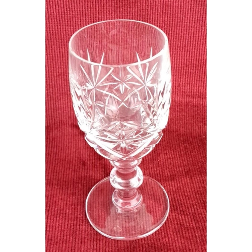 43 - Set of six cut crystal wine glasses with starburst pattern and ornate stems.