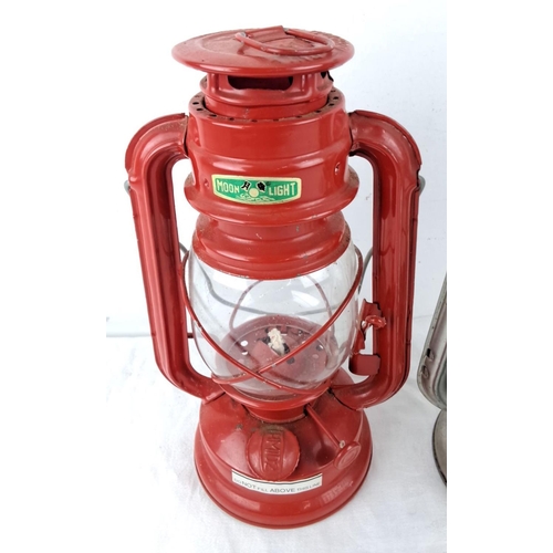 56 - Set of two vintage hurricane lanterns, featuring a red Moon R Light lantern and a silver-tone Free J... 