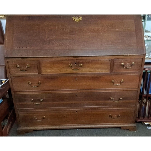 64 - Late Georgian oak bureau with brass handles, featuring a fall-front desk and four graduated drawers ... 