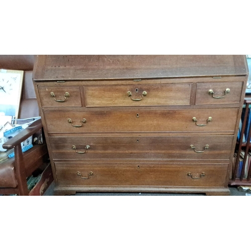 64 - Late Georgian oak bureau with brass handles, featuring a fall-front desk and four graduated drawers ... 