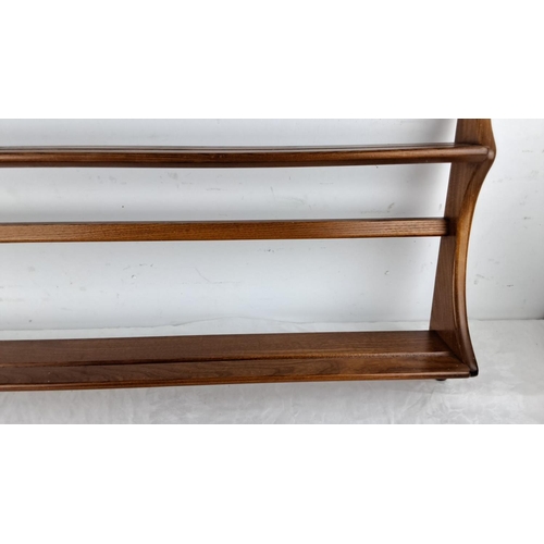 73 - An Ercol oak wood three-tier plate rack with a rich, dark stain has elegantly curved sides and wall ... 