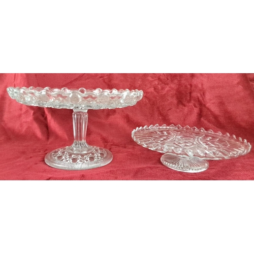 105 - Pair of clear glass pedestal cake stands with intricately patterned designs.