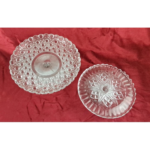 105 - Pair of clear glass pedestal cake stands with intricately patterned designs.