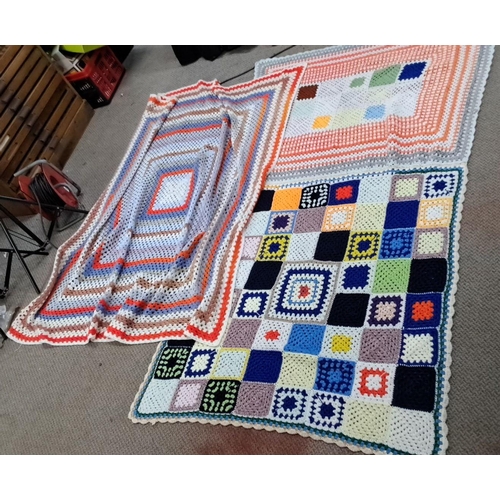 126 - Set of three crocheted blankets, displaying varied geometric patterns and vibrant colors.