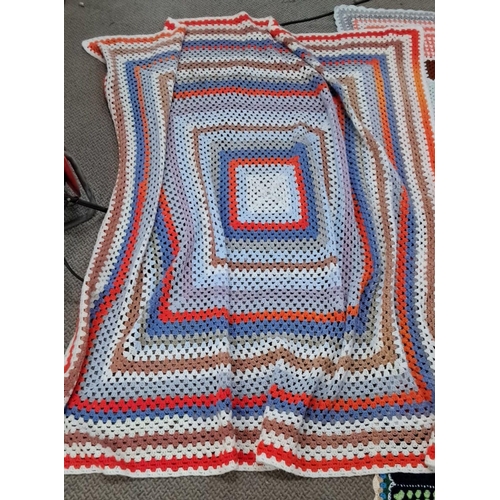 126 - Set of three crocheted blankets, displaying varied geometric patterns and vibrant colors.