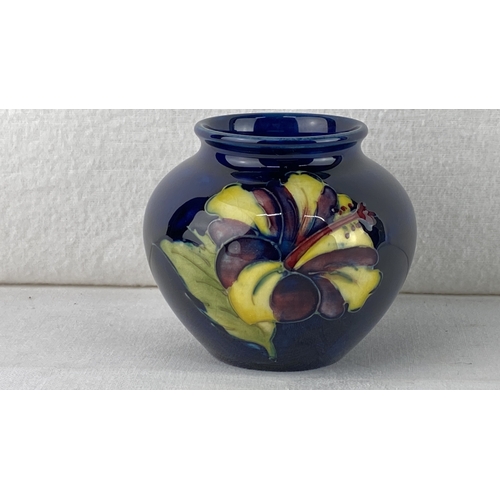 13 - Moorcroft pottery vase with floral motifs on a deep blue ground, measuring 7cm.