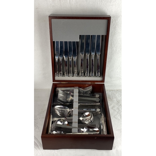 100 - Canteen of Viners cutlery set in a polished wooden case. The set includes knives, forks, spoons, and... 