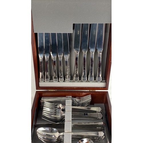 100 - Canteen of Viners cutlery set in a polished wooden case. The set includes knives, forks, spoons, and... 