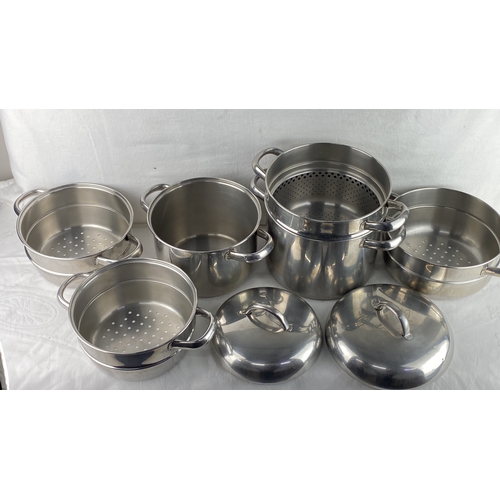 54 - Set of stainless steel steamer pots with lids, featuring multiple compartments. High-quality constru... 