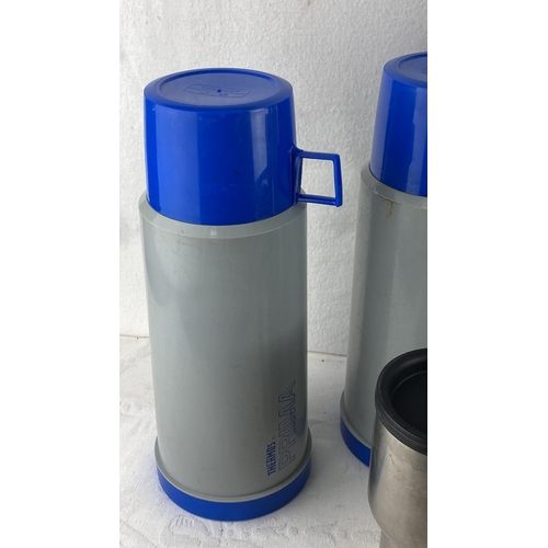 55 - Set of five Thermos containers, including three large plastic models (two with blue caps and one wit... 