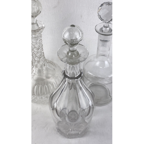 61 - Set of three vintage crystal decanters with cut-glass stoppers featuring ornate and clear designs.