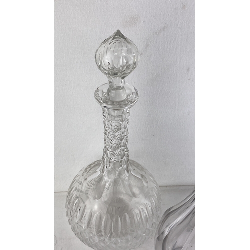 61 - Set of three vintage crystal decanters with cut-glass stoppers featuring ornate and clear designs.