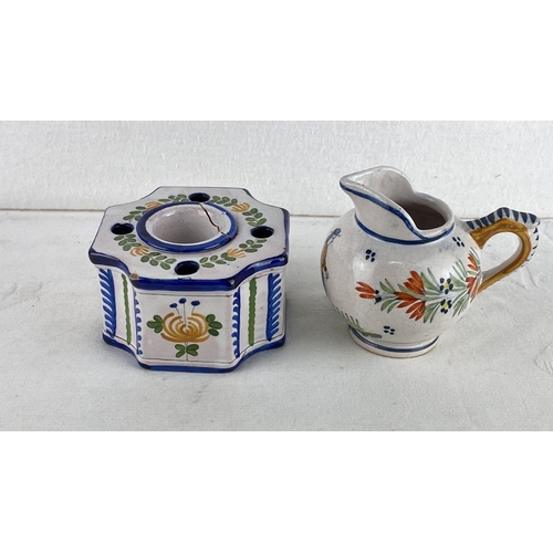 62 - French pottery set, including a jug and a candleholder, with hand-painted floral designs. Marked 