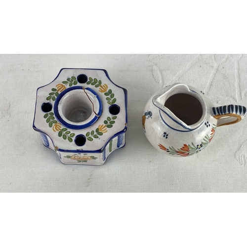 62 - French pottery set, including a jug and a candleholder, with hand-painted floral designs. Marked 