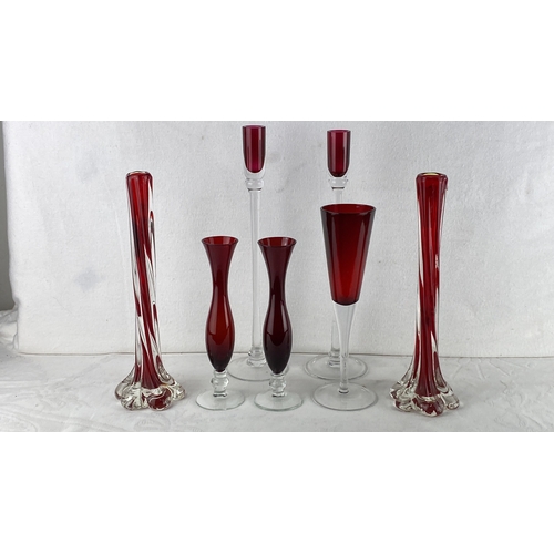 69 - Collection of ruby-red glass vases and champagne flutes with transparent bases, featuring elegant, v... 