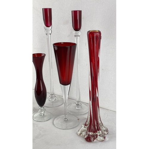 69 - Collection of ruby-red glass vases and champagne flutes with transparent bases, featuring elegant, v... 