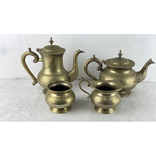 85 - Brass tea set comprising a teapot, coffee pot, creamer, and sugar bowl, each adorned with engraved f... 