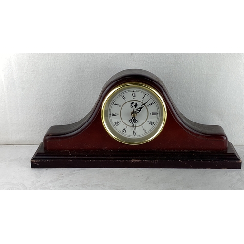 88 - Wooden mantel clock with rounded arch design, brass bezel, Roman numerals, and black intricate hands... 