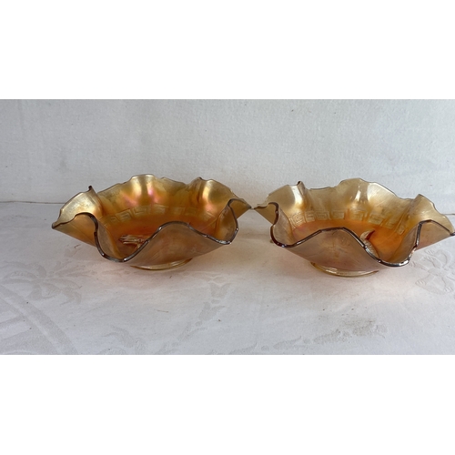 97 - Pair of iridescent glass bowls with ruffled edges, featuring a central motif of a horse's head and a... 