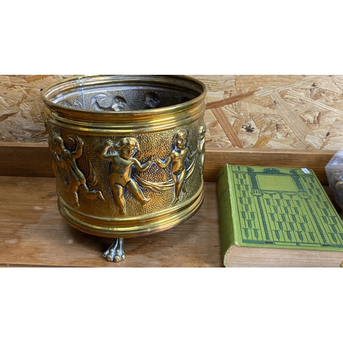 242 - Antique brass planter featuring cherub motifs on claw feet.