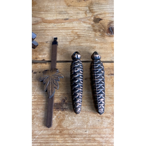 249 - Wooden cuckoo clock with carved maple leaf design, two pinecone weights, chain, and pendulum.