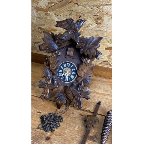 249 - Wooden cuckoo clock with carved maple leaf design, two pinecone weights, chain, and pendulum.