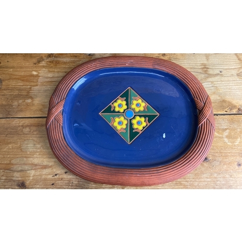 252 - Ceramic platter by Lotus, 1996, features a vibrant floral motif on blue glaze with a textured terrac... 