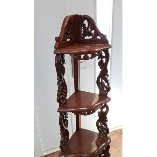 107 - Corner whatnot stand, made of mahogany, features intricate carved floral and vine motifs, with four ... 