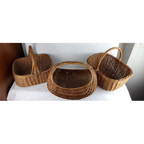 143 - Set of three vintage woven wicker baskets featuring varied handle styles and shapes.