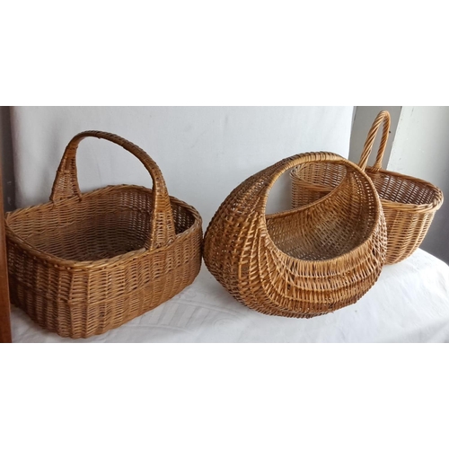 143 - Set of three vintage woven wicker baskets featuring varied handle styles and shapes.