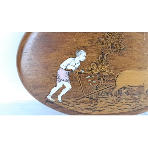 147 - Wood plaque featuring a carved and inlaid farmer with oxen scene.