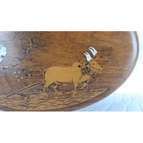 147 - Wood plaque featuring a carved and inlaid farmer with oxen scene.