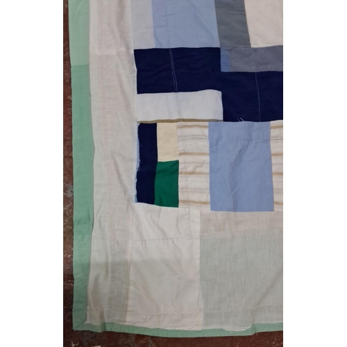 153 - Patchwork quilt features a variety of cotton fabric squares in blue, green, beige, and white hues.